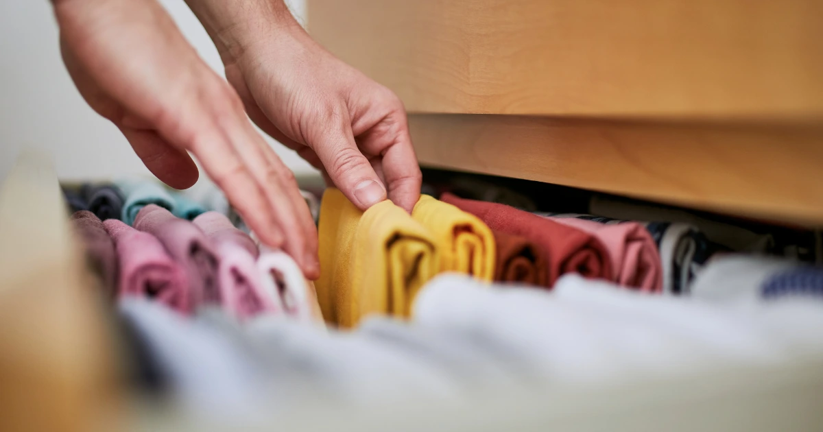 Personne qui ordonne un tiroir de vêtements
