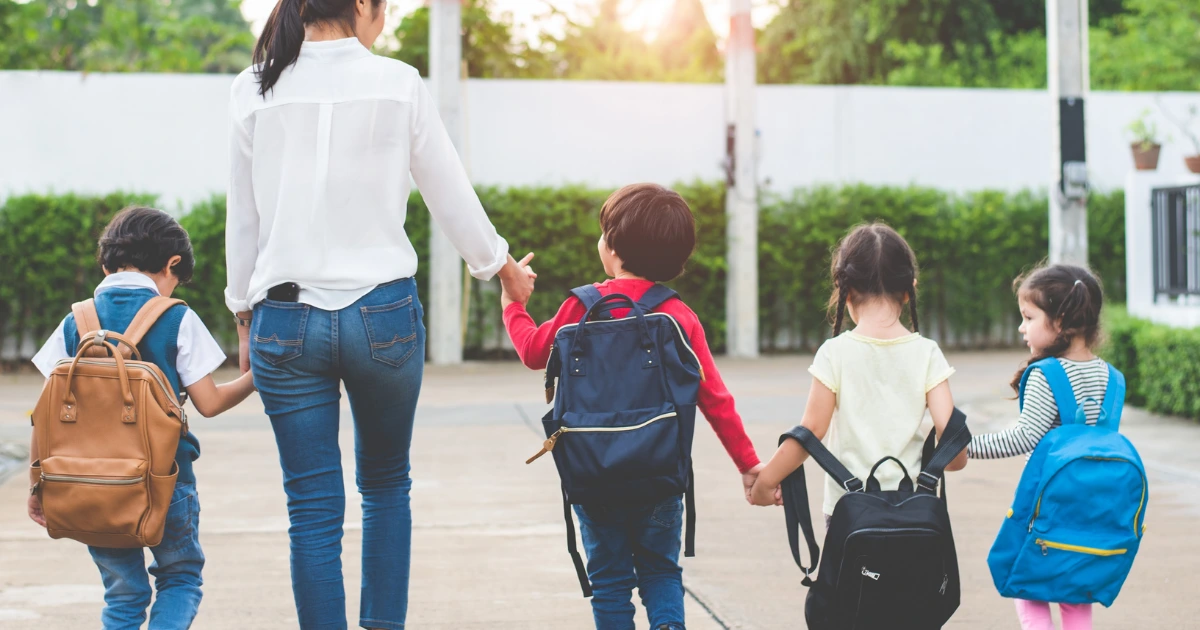 Femme avec plusieurs enfants en route pour l'école
